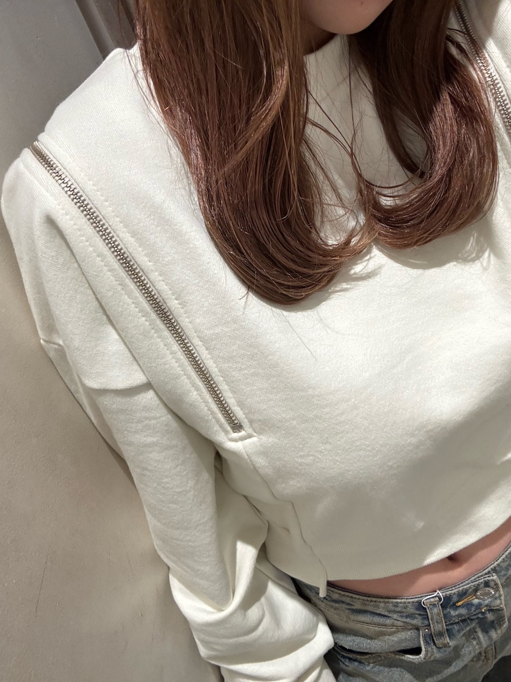 ブルー系のデニムパンツ、ホワイト系のスウェット、ブラック系のブーツを着用したレディースの冬コーディネートの5枚目の写真