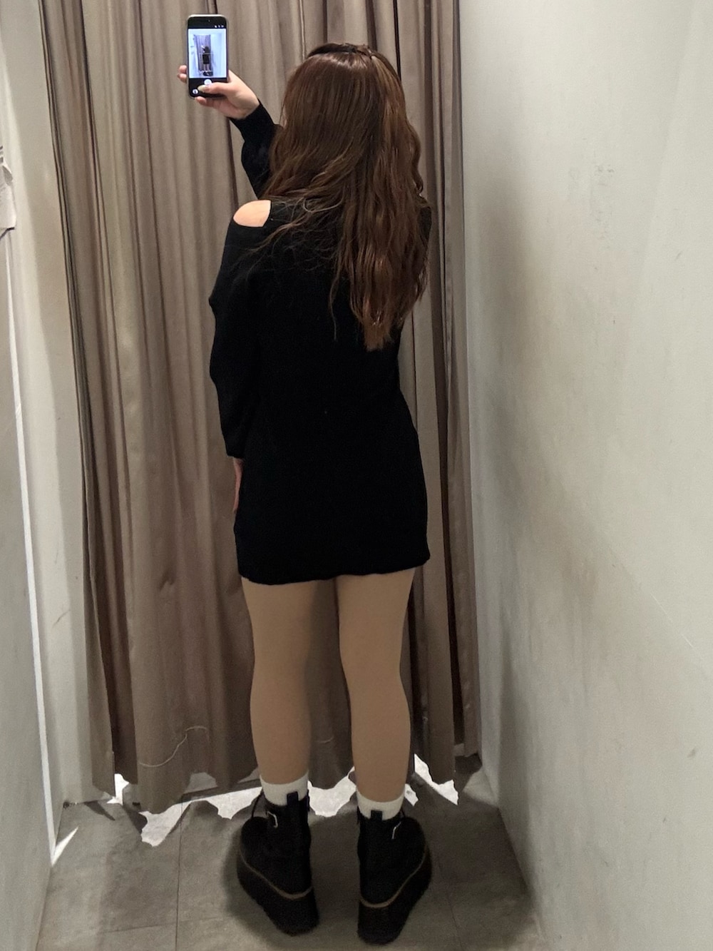 ブラック系のワンピース、ブラック系のブーツを着用したレディースの冬コーディネートの3枚目の写真