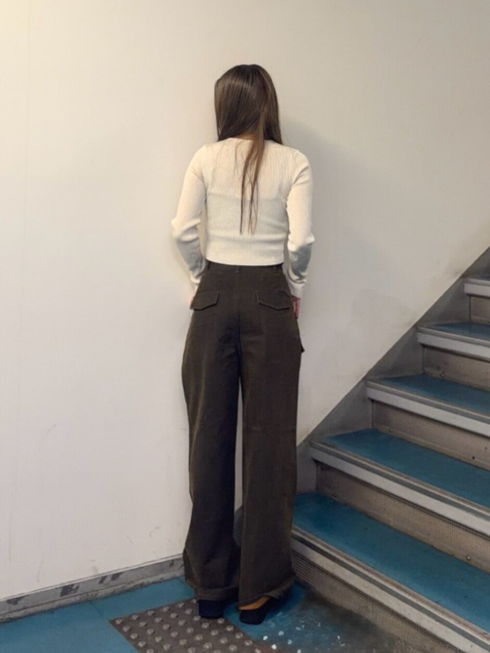 ブラック系のブーツ、ブラウン系のカーゴパンツ、ホワイト系のニット/セーターを着用したレディースの秋コーディネートの3枚目の写真