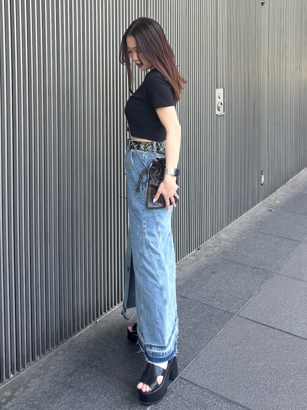 ブラック系のTシャツ/カットソー、ブルー系のデニムスカート、ブラック系のサンダルを着用したレディースの春コーディネートの2枚目の写真