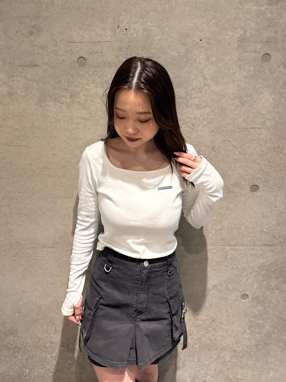 ホワイト系のTシャツ/カットソー、ブラック系のスカート、ブラウン系のブーツを着用したレディースの春コーディネートの4枚目の写真