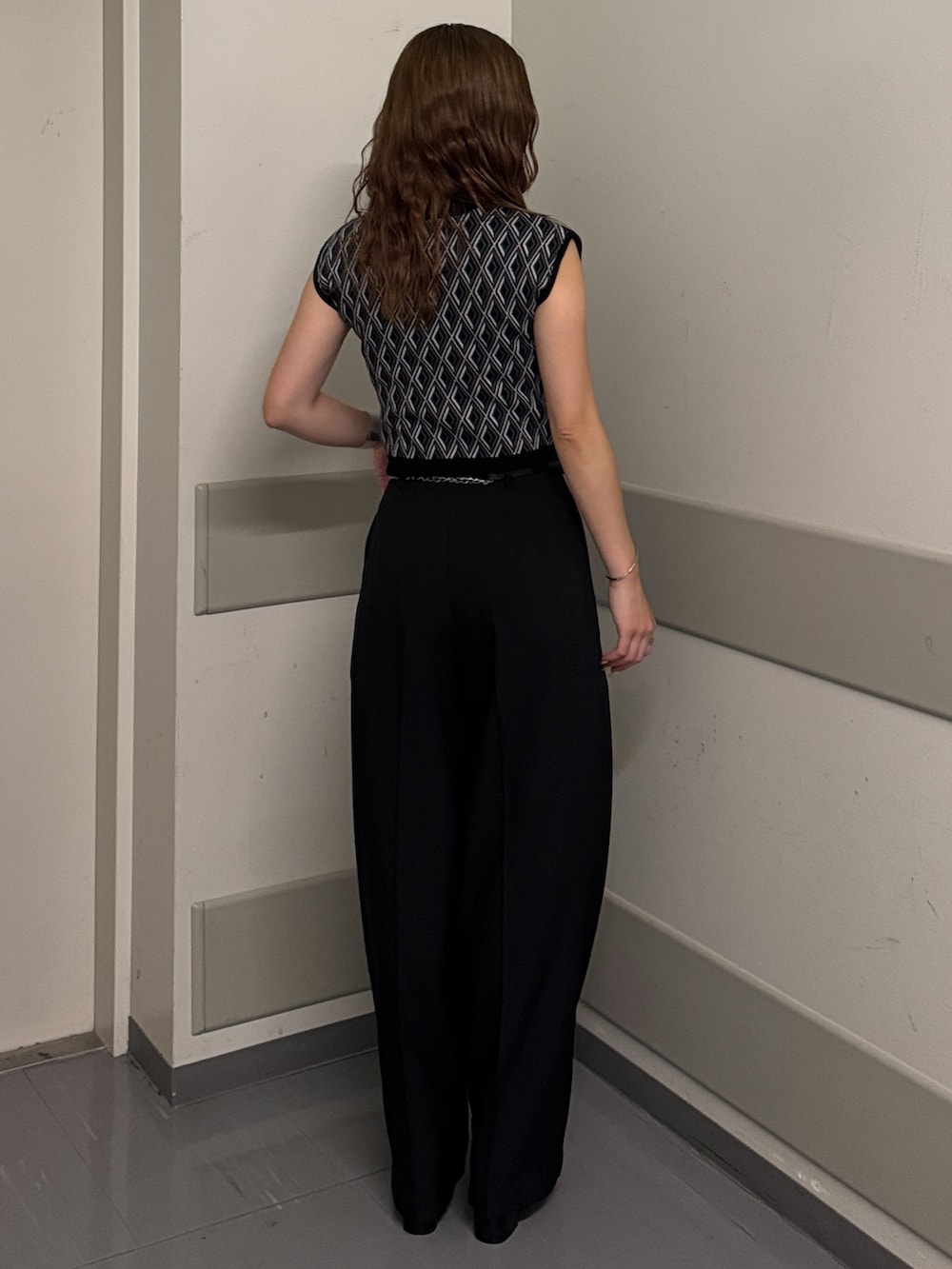 ブラック系のタンクトップ、ブラック系のスラックス、ブラック系のサンダルを着用したレディースの夏コーディネートの3枚目の写真