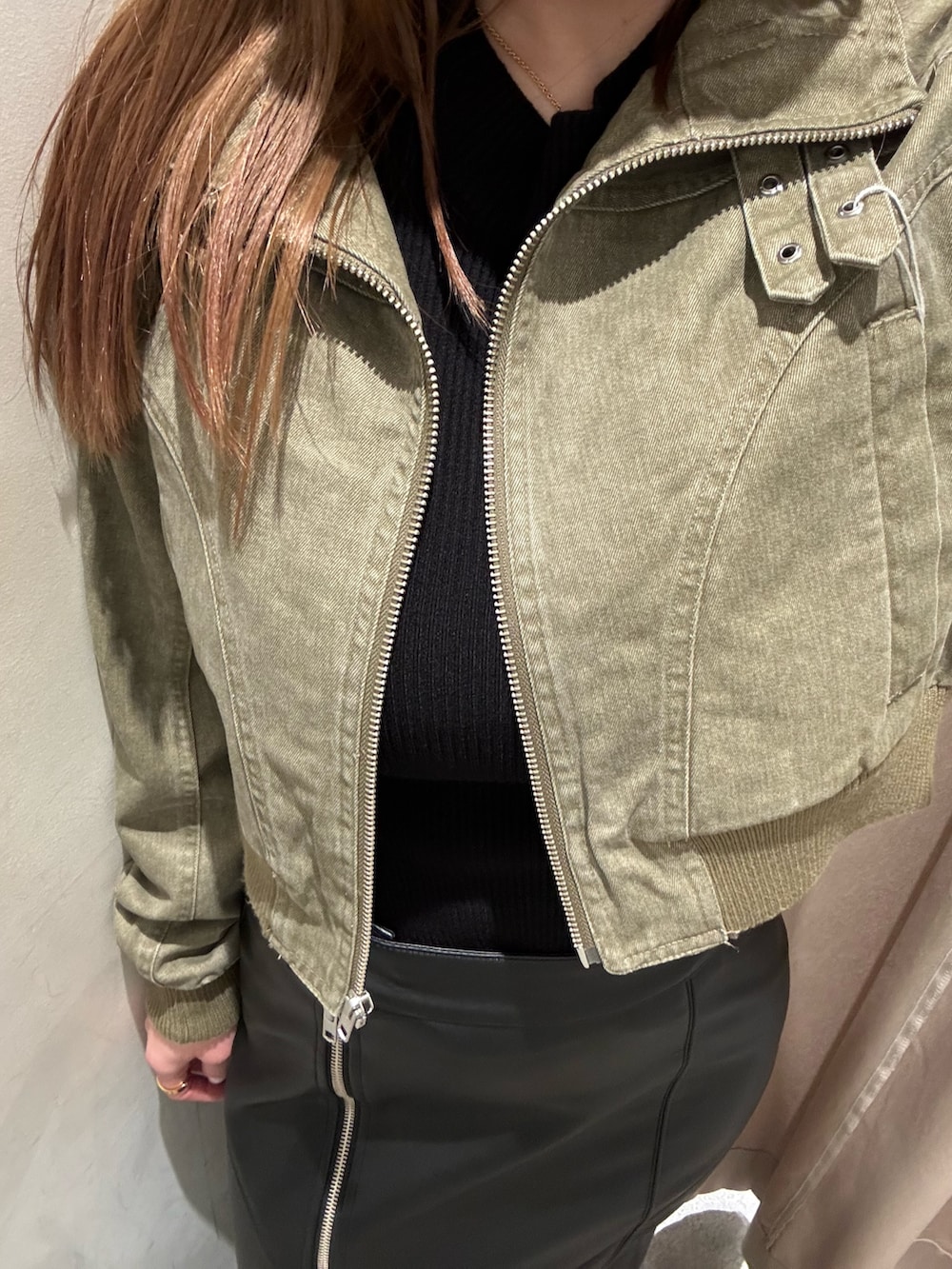 ブラック系のスカート、グリーン系のブルゾン、ブラック系のブーツを着用したレディースの春コーディネートの5枚目の写真