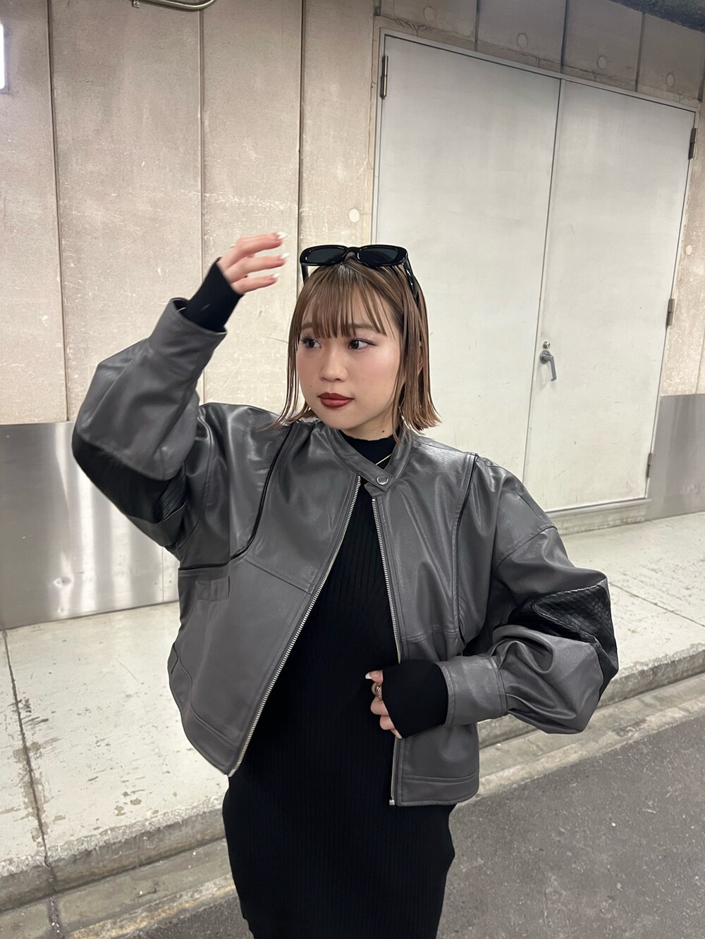 ブラック系のワンピース、グレー系のブルゾンを着用したレディースの冬コーディネートの5枚目の写真