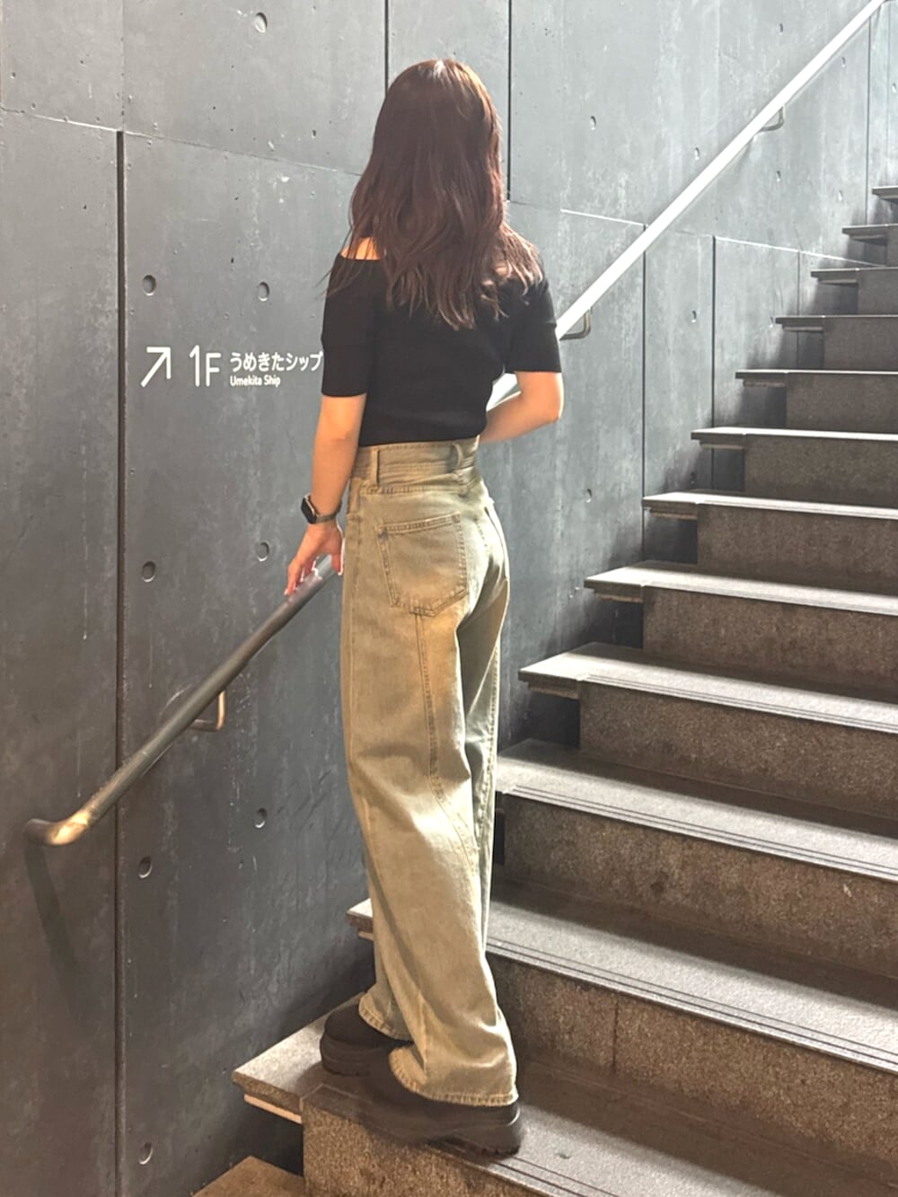 ブルー系のデニムパンツ、ブラック系のブーツ、ブラック系のニット/セーターを着用したレディースの春コーディネートの3枚目の写真