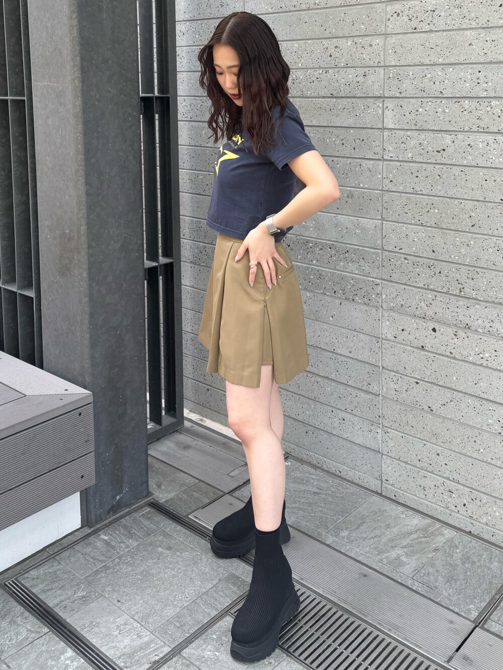 ブルー系のTシャツ/カットソー、ベージュ系のスカート、ブラック系のブーツを着用したレディースの春コーディネートの2枚目の写真