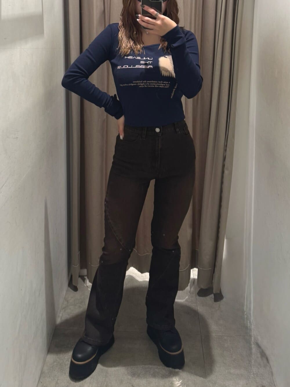 ブラック系のブーツ、ブラウン系のデニムパンツ、ブルー系のTシャツ/カットソーを着用したレディースの秋コーディネートの5枚目の写真