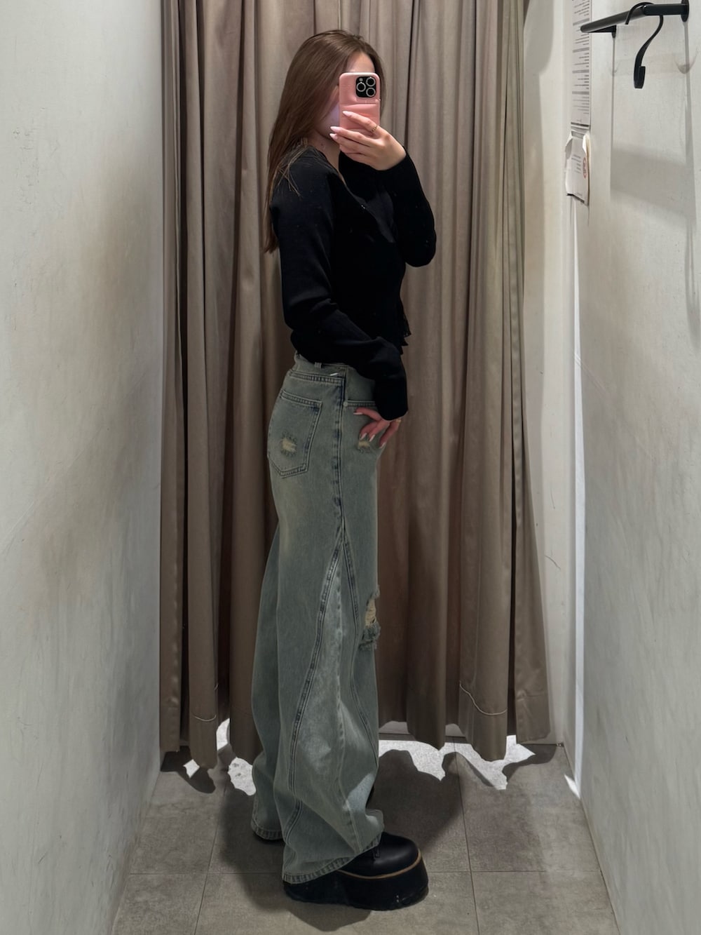 ブルー系のデニムパンツ、ブラック系のニット/セーター、ブラック系のブーツを着用したレディースの春コーディネートの2枚目の写真