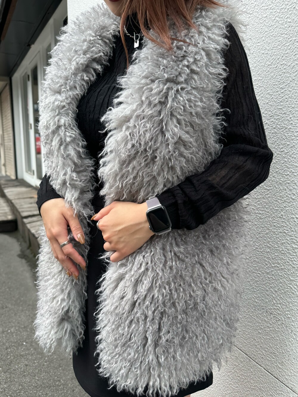 ブラック系のニット/セーター、グレー系のベスト、ブラック系のスカートを着用したレディースの秋コーディネートの6枚目の写真