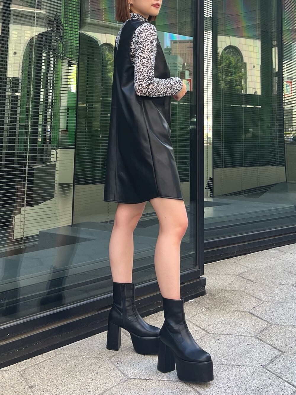 ホワイト系のTシャツ/カットソー、ブラック系のワンピース、ブラック系のブーツを着用したレディースの夏コーディネートの2枚目の写真