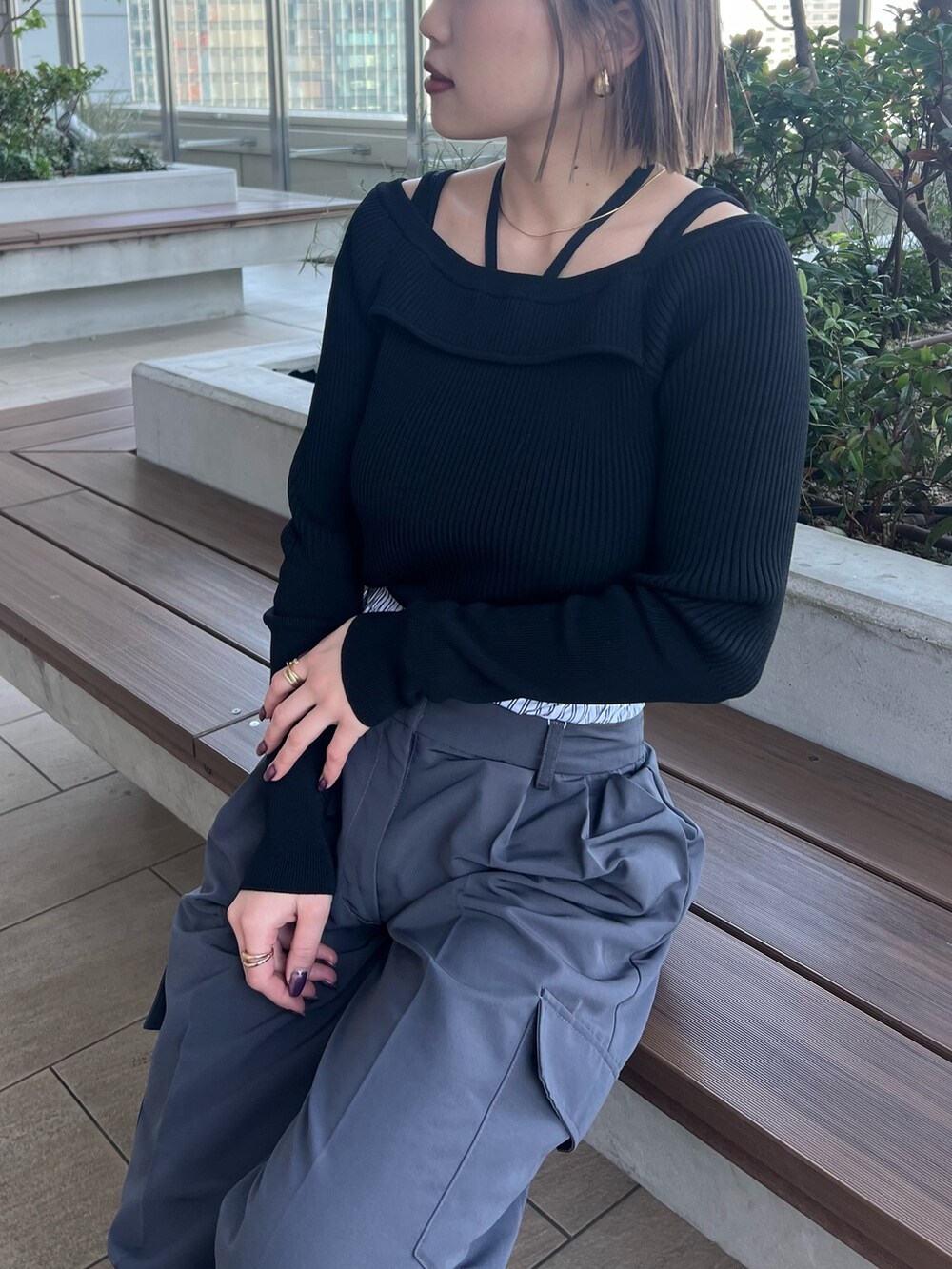 ブラック系のニット/セーター、グレー系のその他パンツを着用したレディースの春コーディネートの7枚目の写真