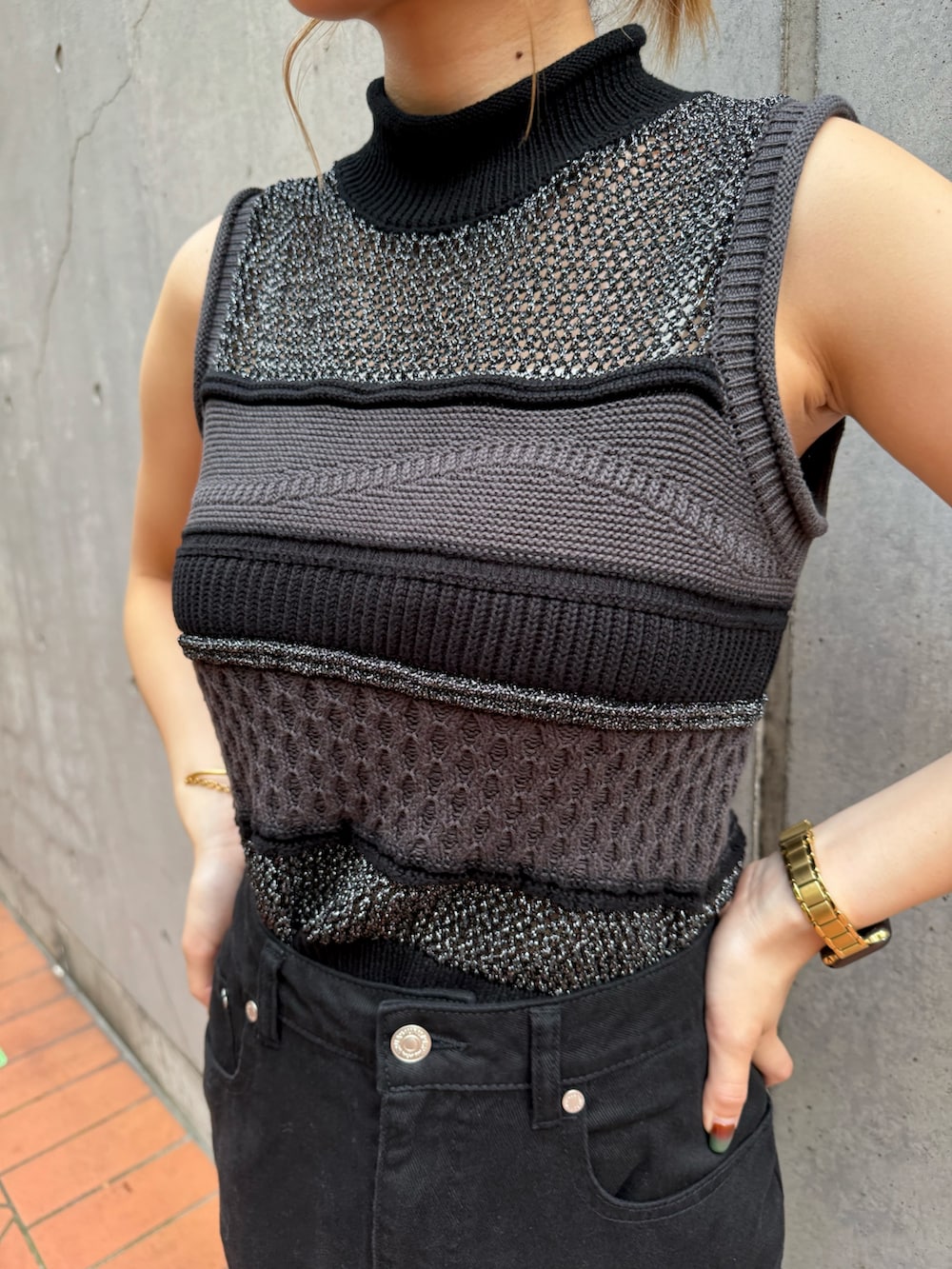 ブラック系のニット/セーター、ブラック系のデニムスカートを着用したレディースの夏コーディネートの6枚目の写真