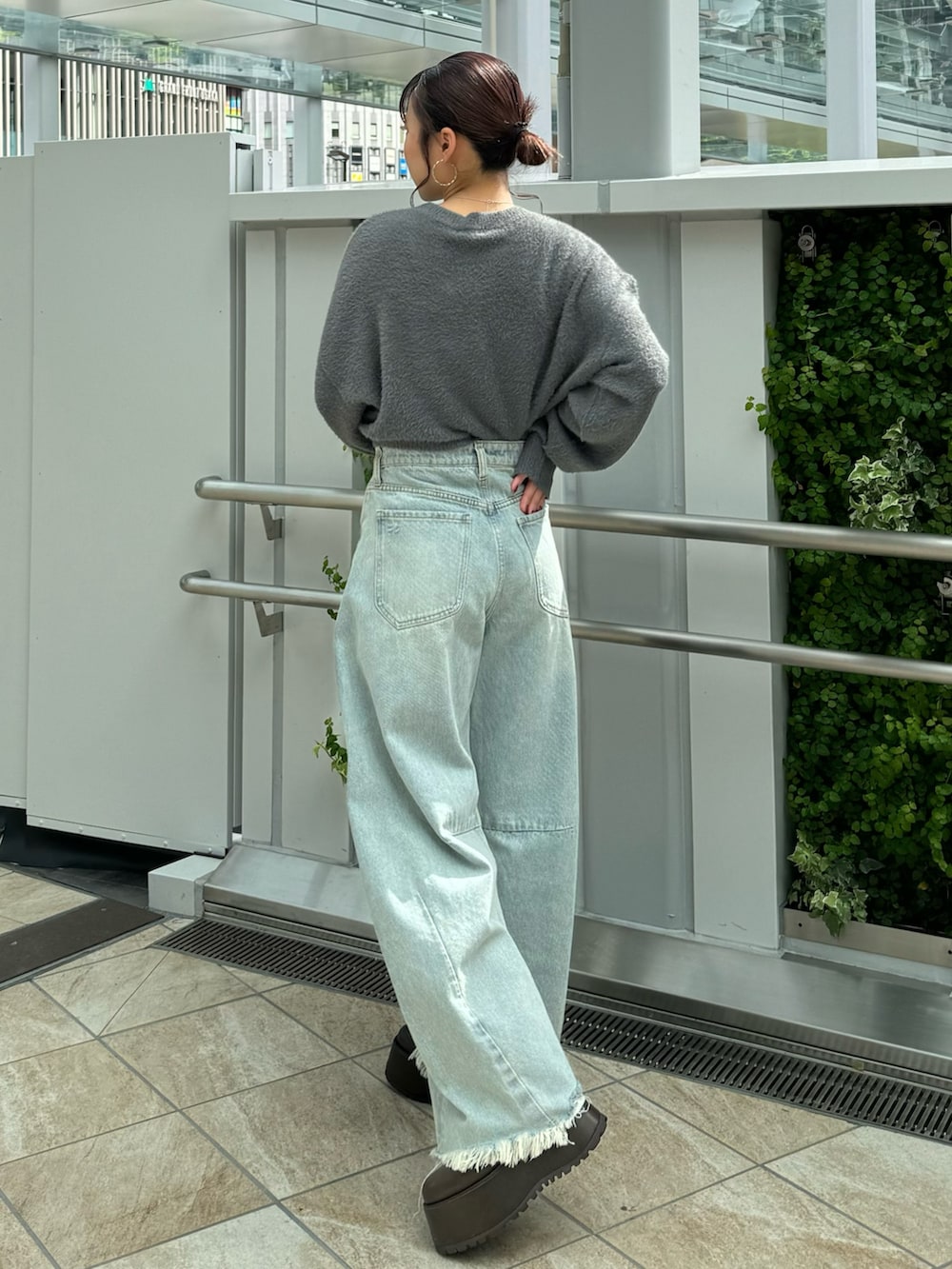 グレー系のニット/セーター、ブルー系のデニムパンツ、ブラウン系のブーツを着用したレディースの秋コーディネートの3枚目の写真