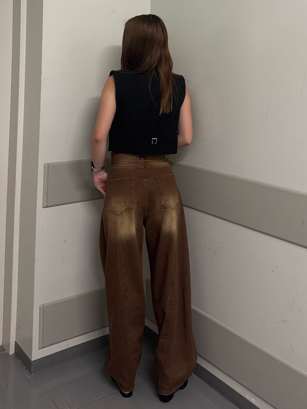 ブラウン系のデニムパンツ、グレー系のタンクトップ、ブラック系のベストを着用したレディースの夏コーディネートの3枚目の写真