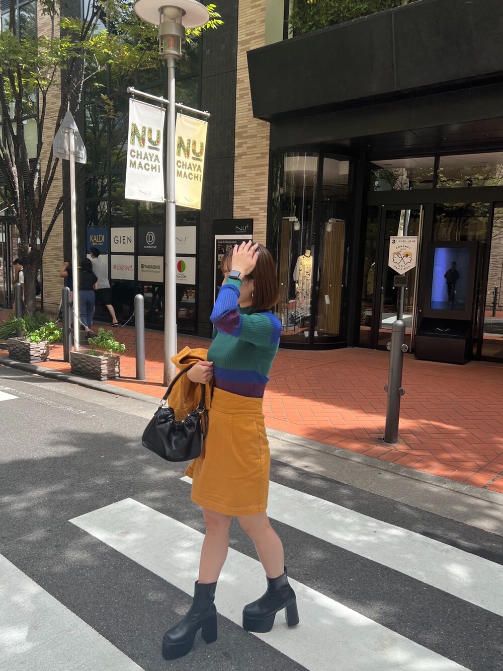 イエロー系のデニムジャケット、イエロー系のスカート、グリーン系のニット/セーターを着用したレディースの夏コーディネートの6枚目の写真