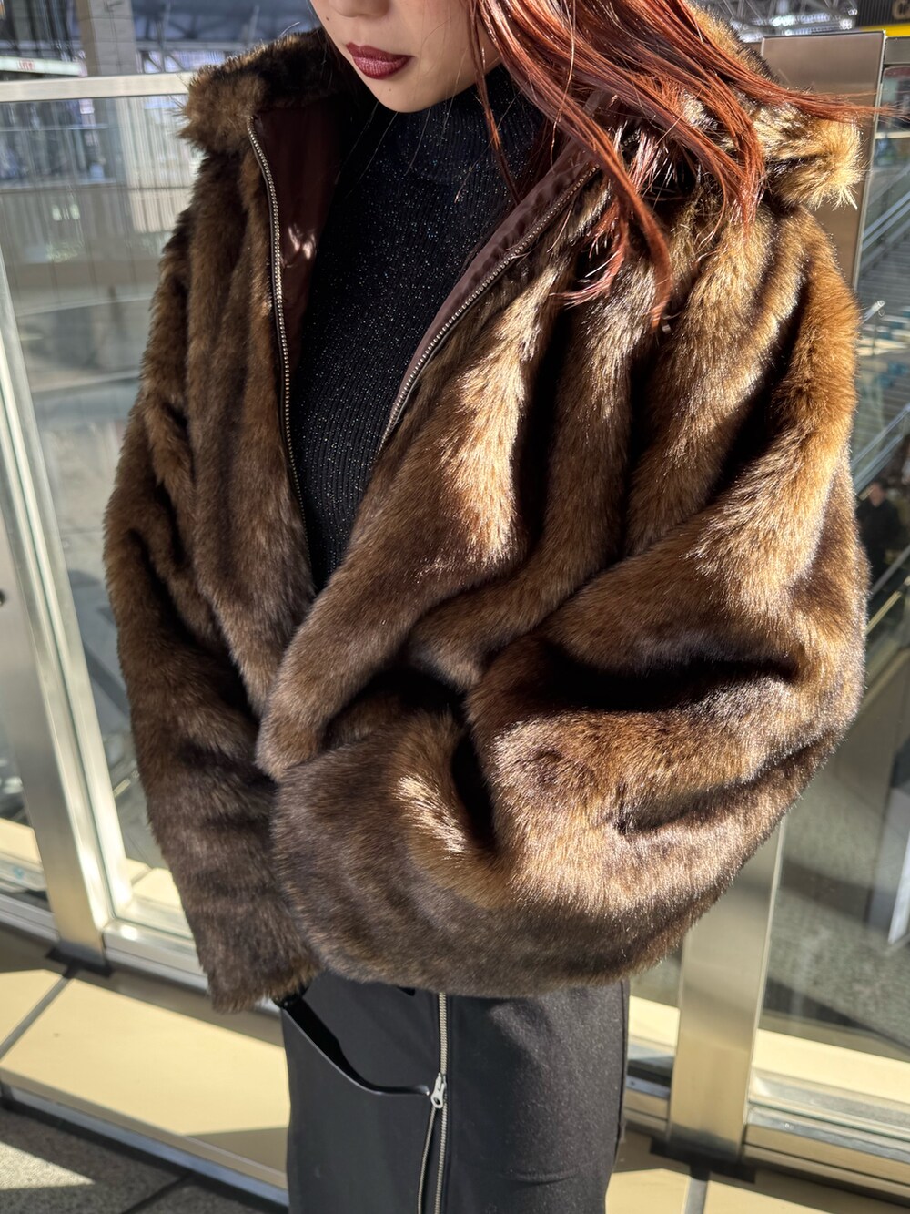 ブラウン系のブルゾン、ブラック系のスカート、ブラック系のブーツを着用したレディースの冬コーディネートの5枚目の写真