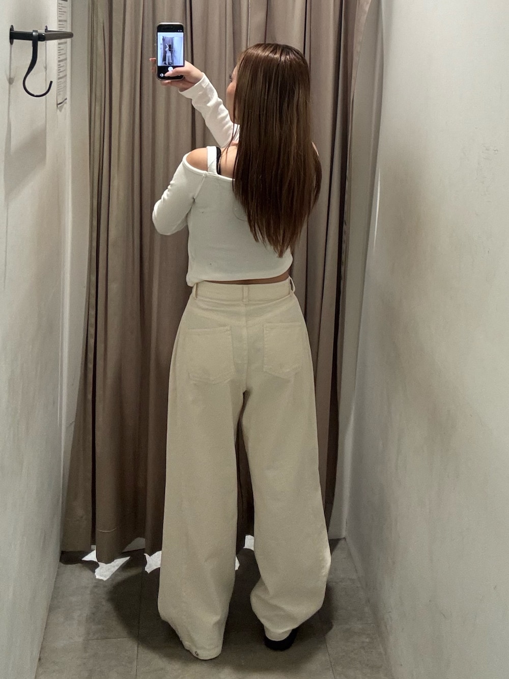 ホワイト系のデニムパンツ、ホワイト系のニット/セーター、ブラック系のブーツを着用したレディースの春コーディネートの3枚目の写真