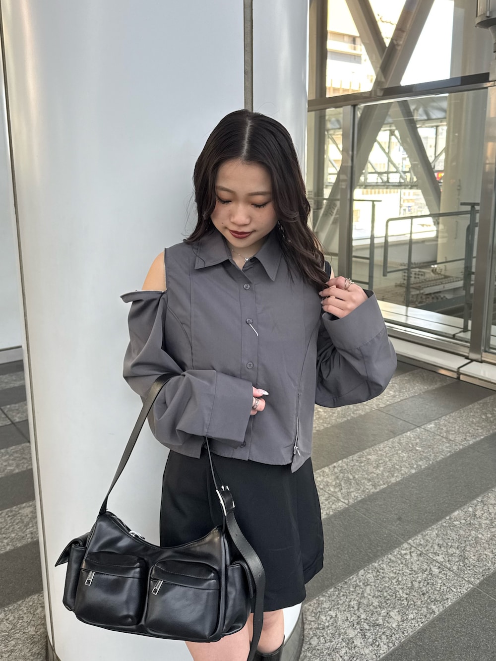 グレー系のシャツ/ブラウス、ブラック系のスカート、ブラウン系のブーツを着用したレディースの春コーディネートの4枚目の写真