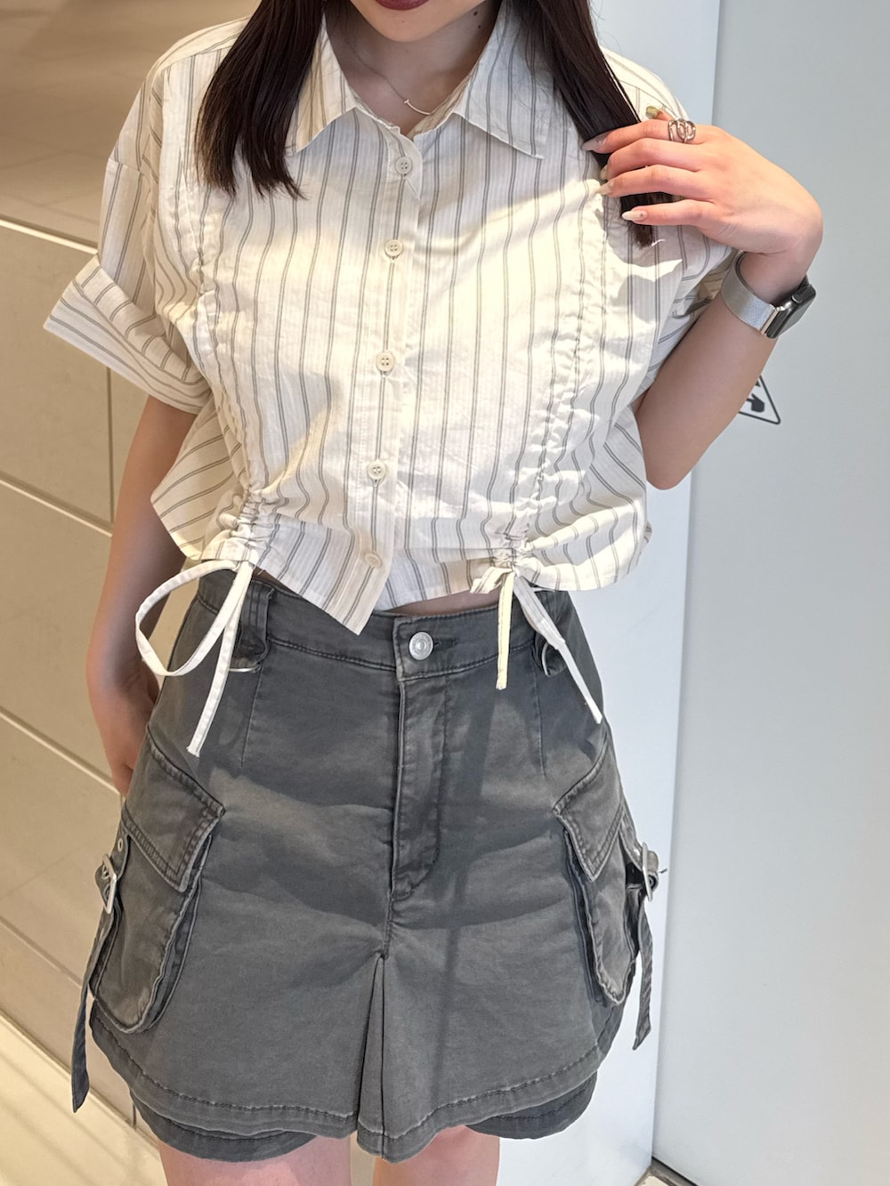 ホワイト系のシャツ/ブラウス、グレー系のスカート、ブラック系のブーツを着用したレディースの春コーディネートの5枚目の写真