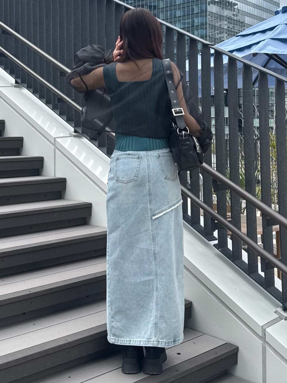 ブルー系のデニムスカート、ブラック系のシャツ/ブラウス、ブルー系のタンクトップを着用したレディースの春コーディネートの3枚目の写真
