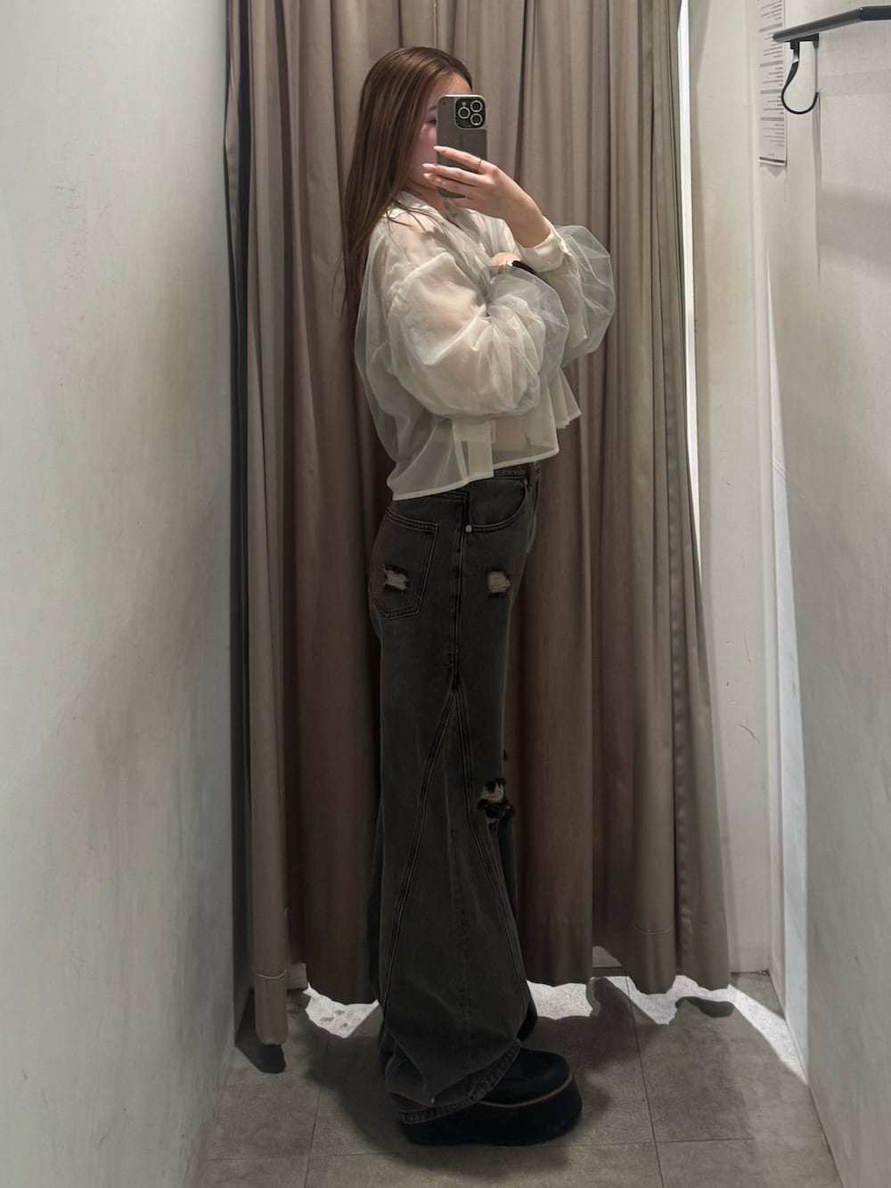 グレー系のデニムパンツ、イエロー系のシャツ/ブラウス、ブラック系のブーツを着用したレディースの春コーディネートの2枚目の写真