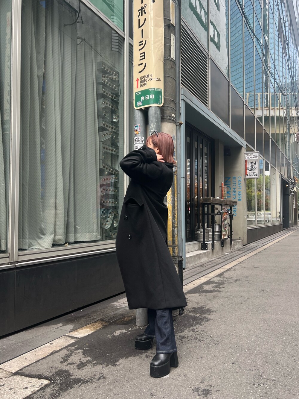 ブラック系のチェスターコートを着用したレディースの秋コーディネートの5枚目の写真