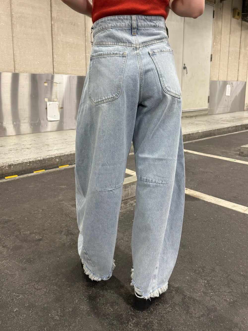 オレンジ系のニット/セーター、ブルー系のデニムパンツを着用したレディースの夏コーディネートの8枚目の写真