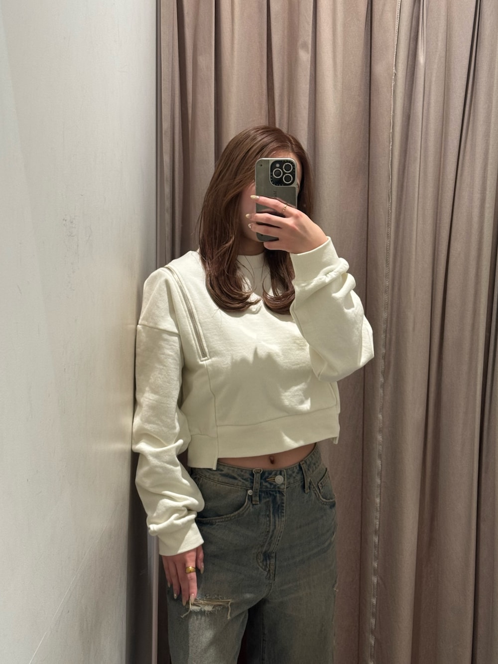 ブルー系のデニムパンツ、ホワイト系のスウェット、ブラック系のブーツを着用したレディースの冬コーディネートの4枚目の写真