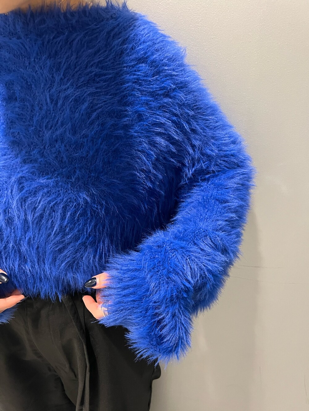 ブルー系のニット/セーター、ブラック系のその他パンツ、ブラック系のブーツを着用したレディースの秋コーディネートの5枚目の写真