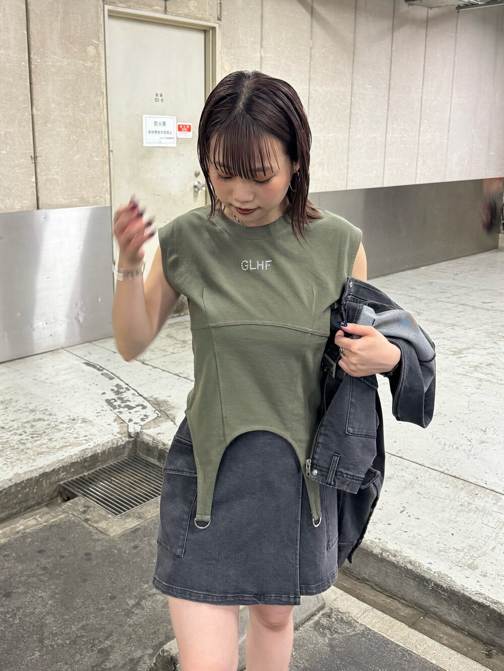 ブラック系のデニムジャケット、ブラック系のスカート、グリーン系のTシャツ/カットソーを着用したレディースの夏コーディネートの6枚目の写真
