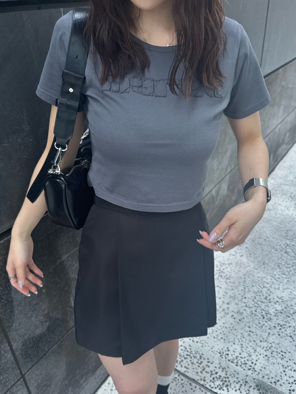 グレー系のTシャツ/カットソー、ブラック系のスカート、ブラック系のブーツを着用したレディースの春コーディネートの4枚目の写真