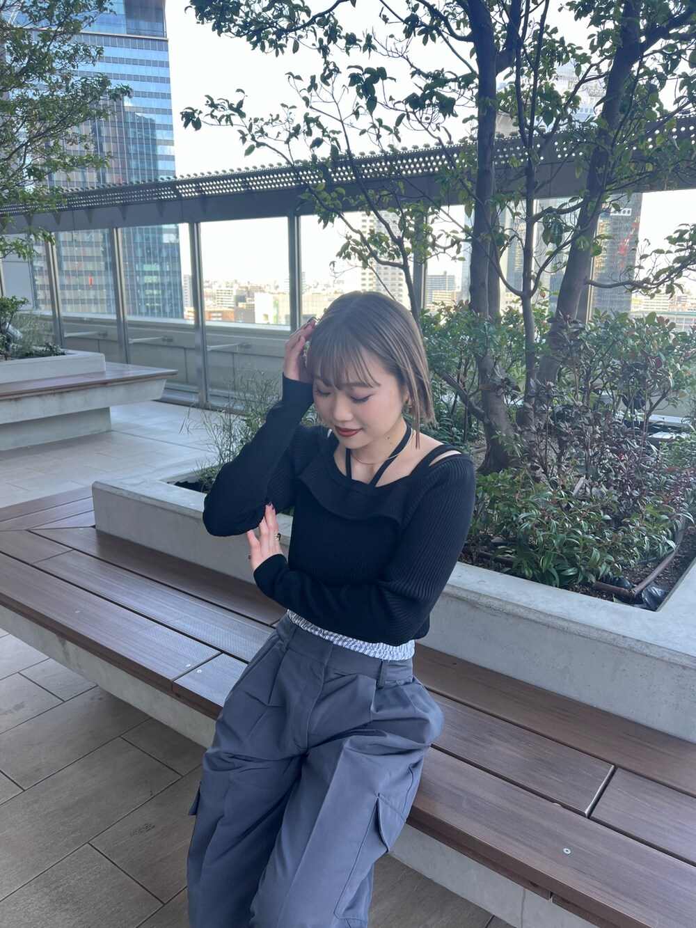 ブラック系のニット/セーター、グレー系のその他パンツを着用したレディースの春コーディネートの5枚目の写真