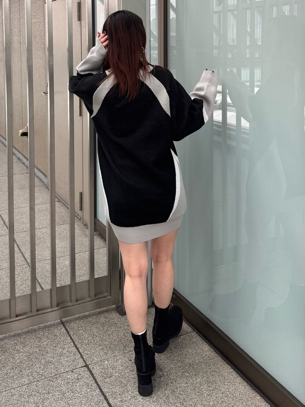 ブラック系のワンピース、ブラック系のブーツを着用したレディースの冬コーディネートの3枚目の写真