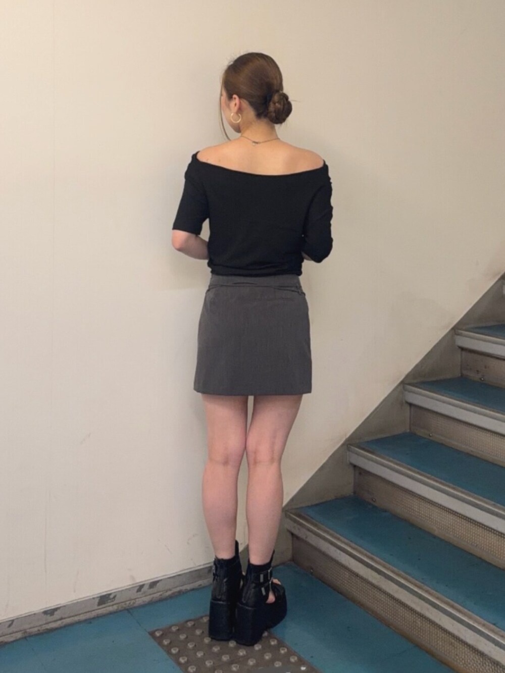 ブラック系のブーツ、ブラック系のTシャツ/カットソー、グレー系のスカートを着用したレディースの夏コーディネートの3枚目の写真