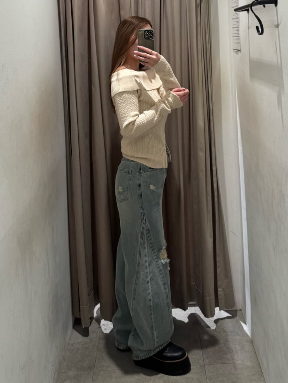 ブラック系のブーツ、ブルー系のデニムパンツ、ホワイト系のニット/セーターを着用したレディースの春コーディネートの2枚目の写真