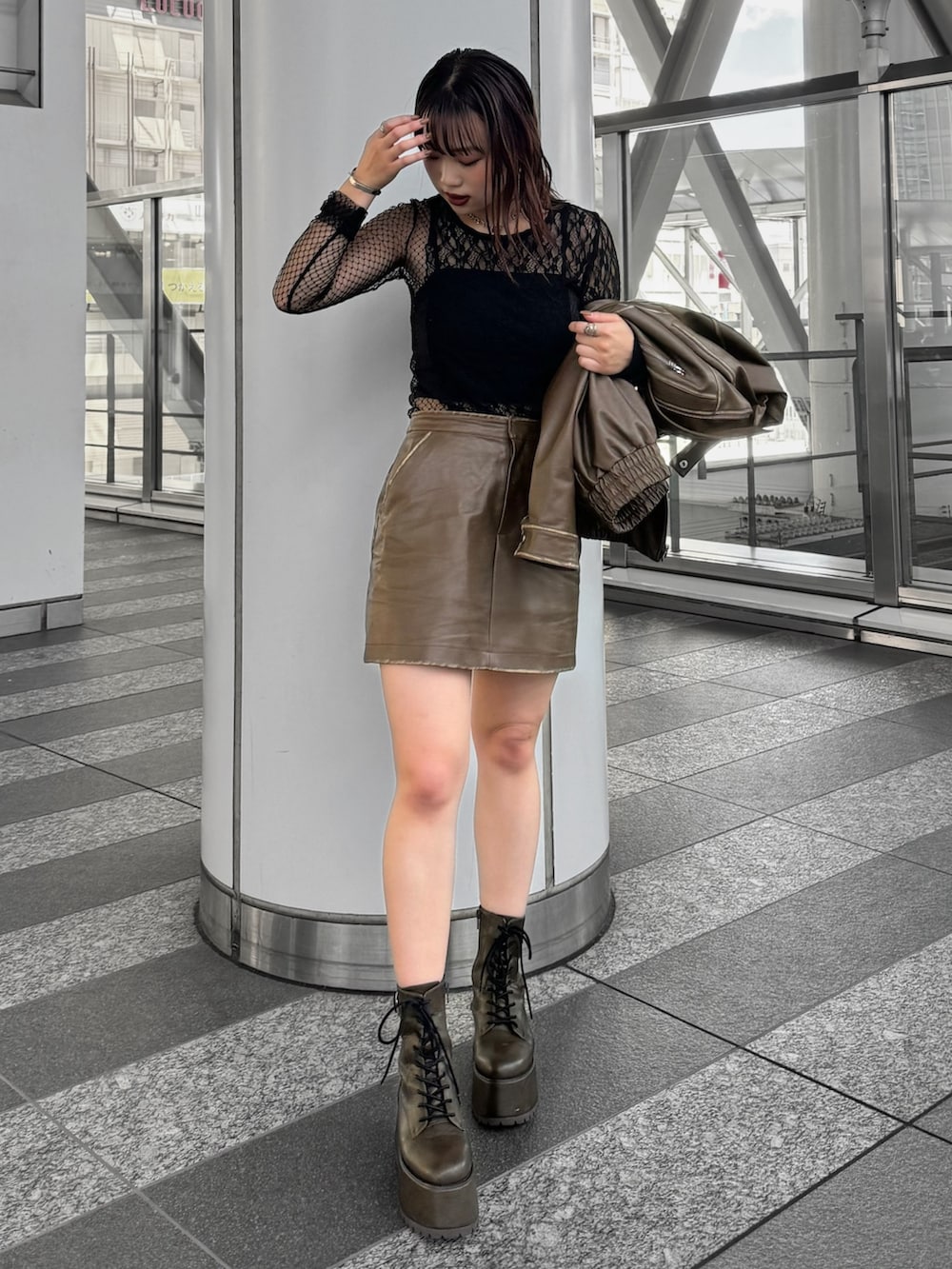 ブラック系のTシャツ/カットソー、ブラウン系のライダースジャケット、ブラウン系のスカートを着用したレディースの秋コーディネートの2枚目の写真