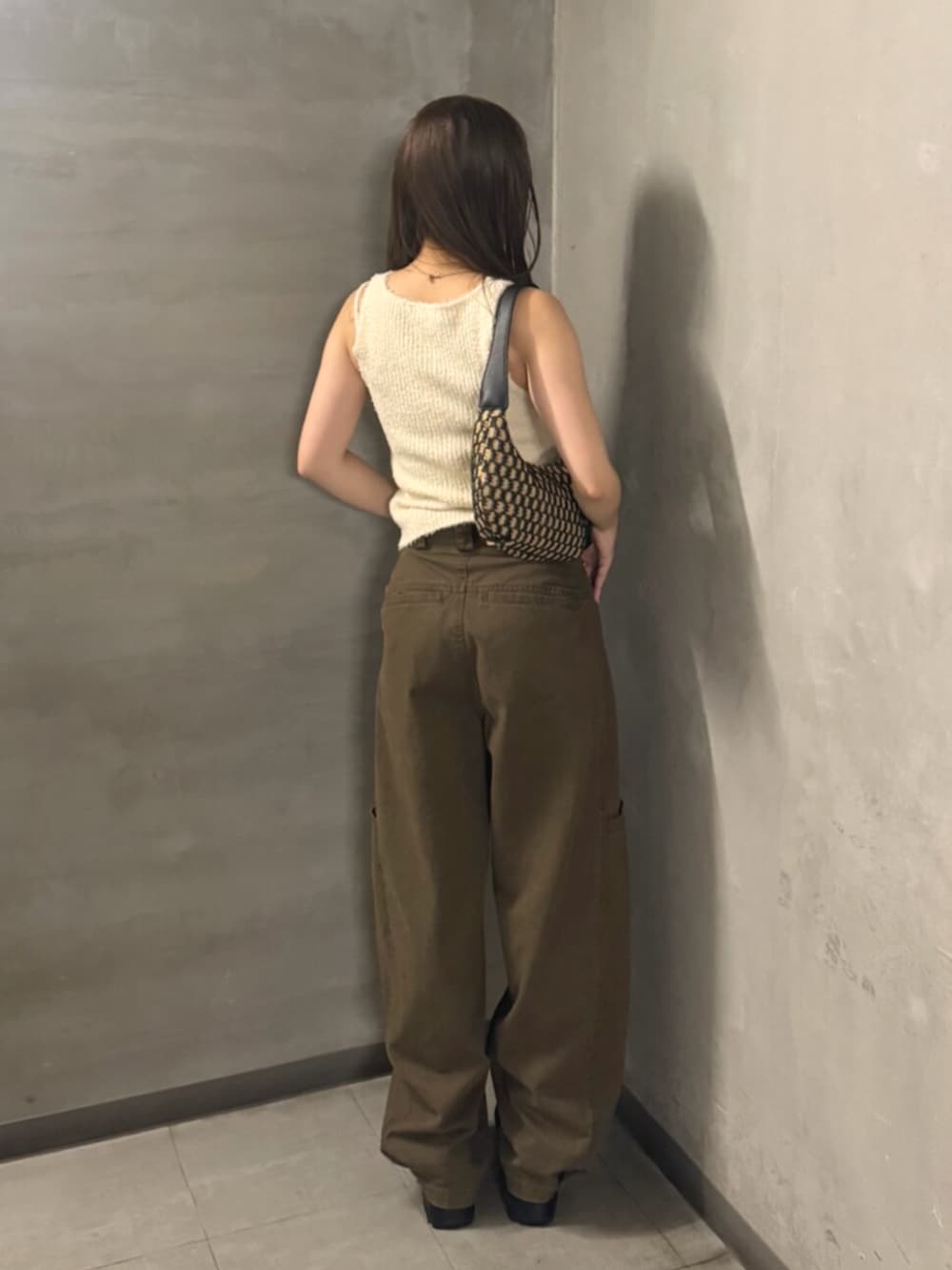 ブラック系のブーツ、ブラウン系のその他パンツ、ホワイト系のタンクトップを着用したレディースの夏コーディネートの3枚目の写真
