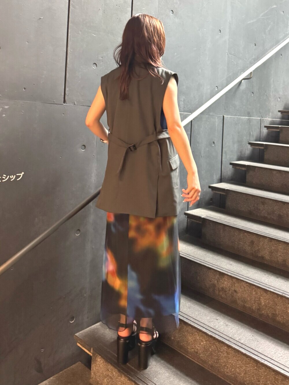 ブラック系のサンダル、グレー系のベスト、ブラック系のワンピースを着用したレディースの夏コーディネートの3枚目の写真