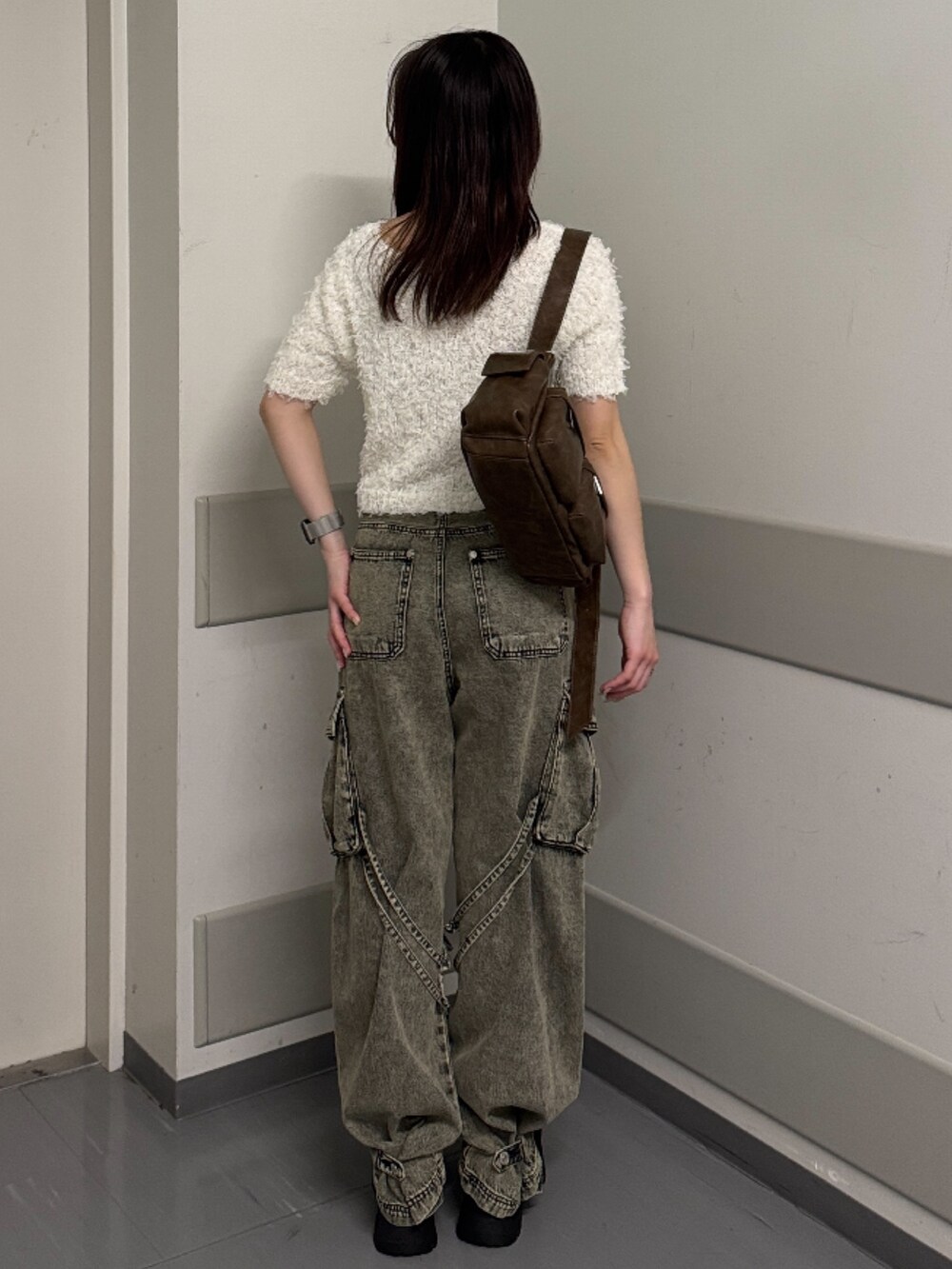 ホワイト系のニット/セーター、ブラック系のデニムパンツ、ブラック系のブーツを着用したレディースの春コーディネートの3枚目の写真