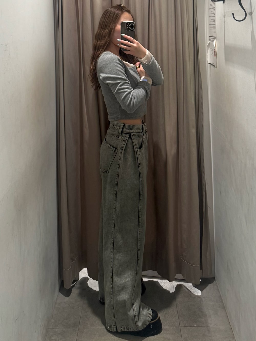 グレー系のTシャツ/カットソー、グリーン系のデニムパンツ、ブラック系のブーツを着用したレディースの冬コーディネートの2枚目の写真