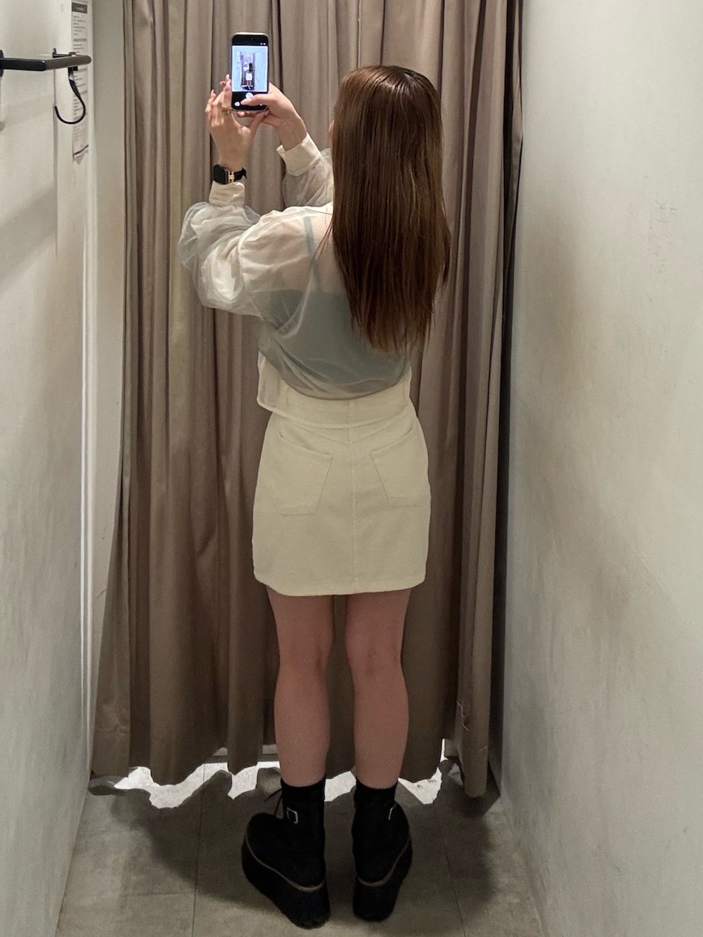 ホワイト系のデニムスカート、イエロー系のシャツ/ブラウス、ブラック系のブーツを着用したレディースの春コーディネートの3枚目の写真