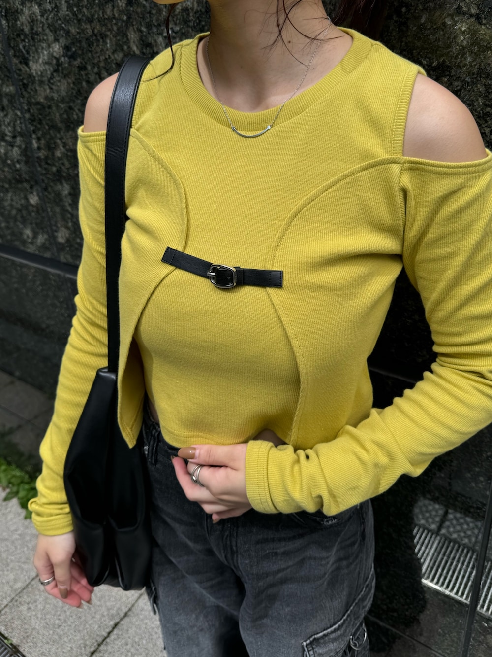 イエロー系のTシャツ/カットソー、ブラック系のデニムパンツ、ブラック系のブーツを着用したレディースの秋コーディネートの7枚目の写真