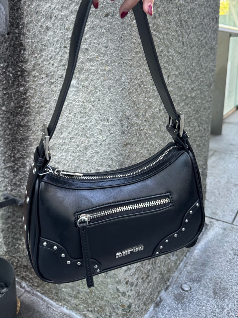 グレー系のスウェット、ブラック系のスカート、ブラック系のハンドバッグを着用したレディースの秋コーディネートの6枚目の写真