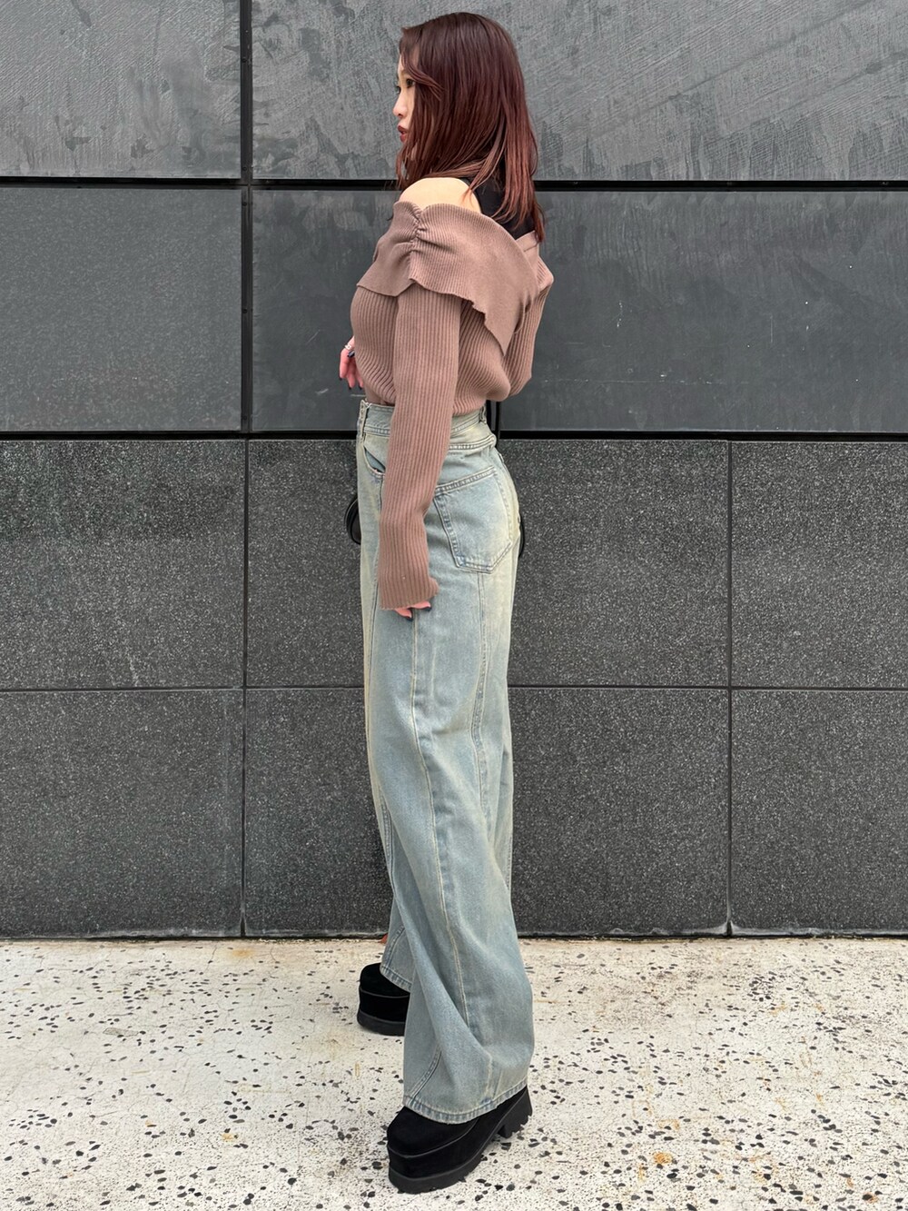 ブラウン系のニット/セーター、ブルー系のデニムパンツ、ブラック系のブーツを着用したレディースの冬コーディネートの2枚目の写真