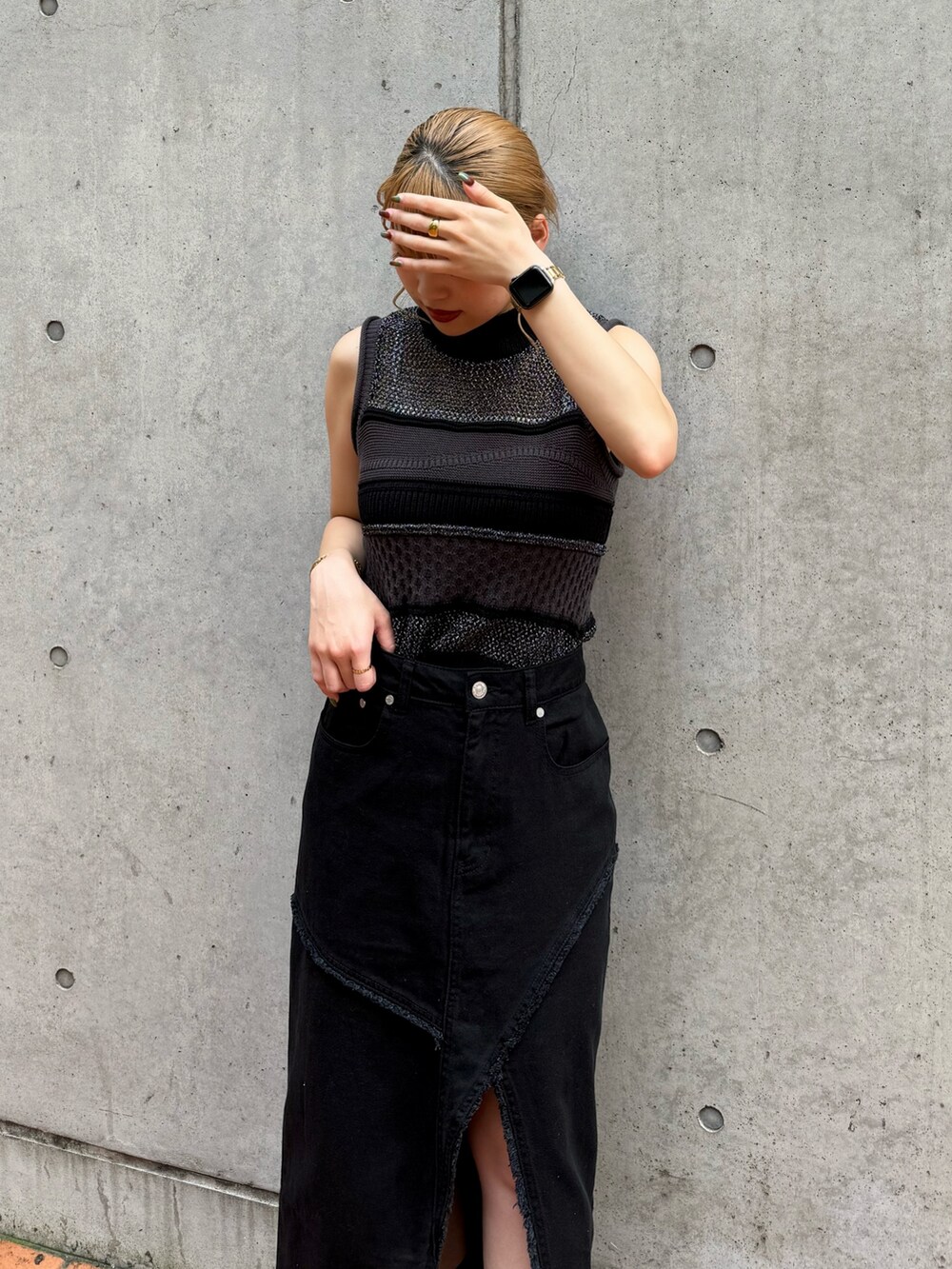 ブラック系のニット/セーター、ブラック系のデニムスカートを着用したレディースの夏コーディネートの5枚目の写真