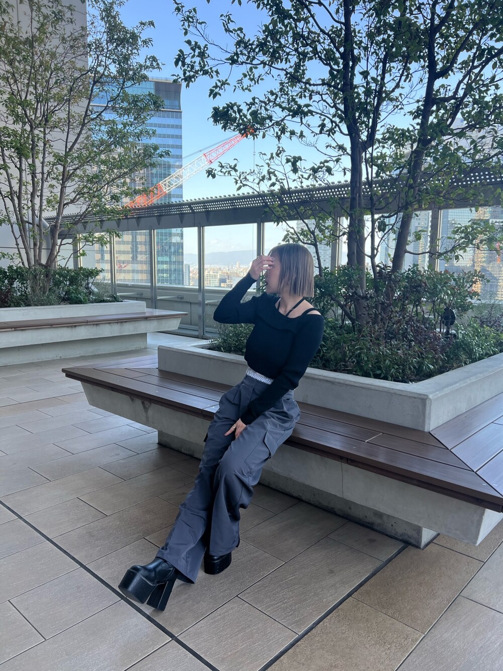 ブラック系のニット/セーター、グレー系のその他パンツを着用したレディースの春コーディネートの4枚目の写真