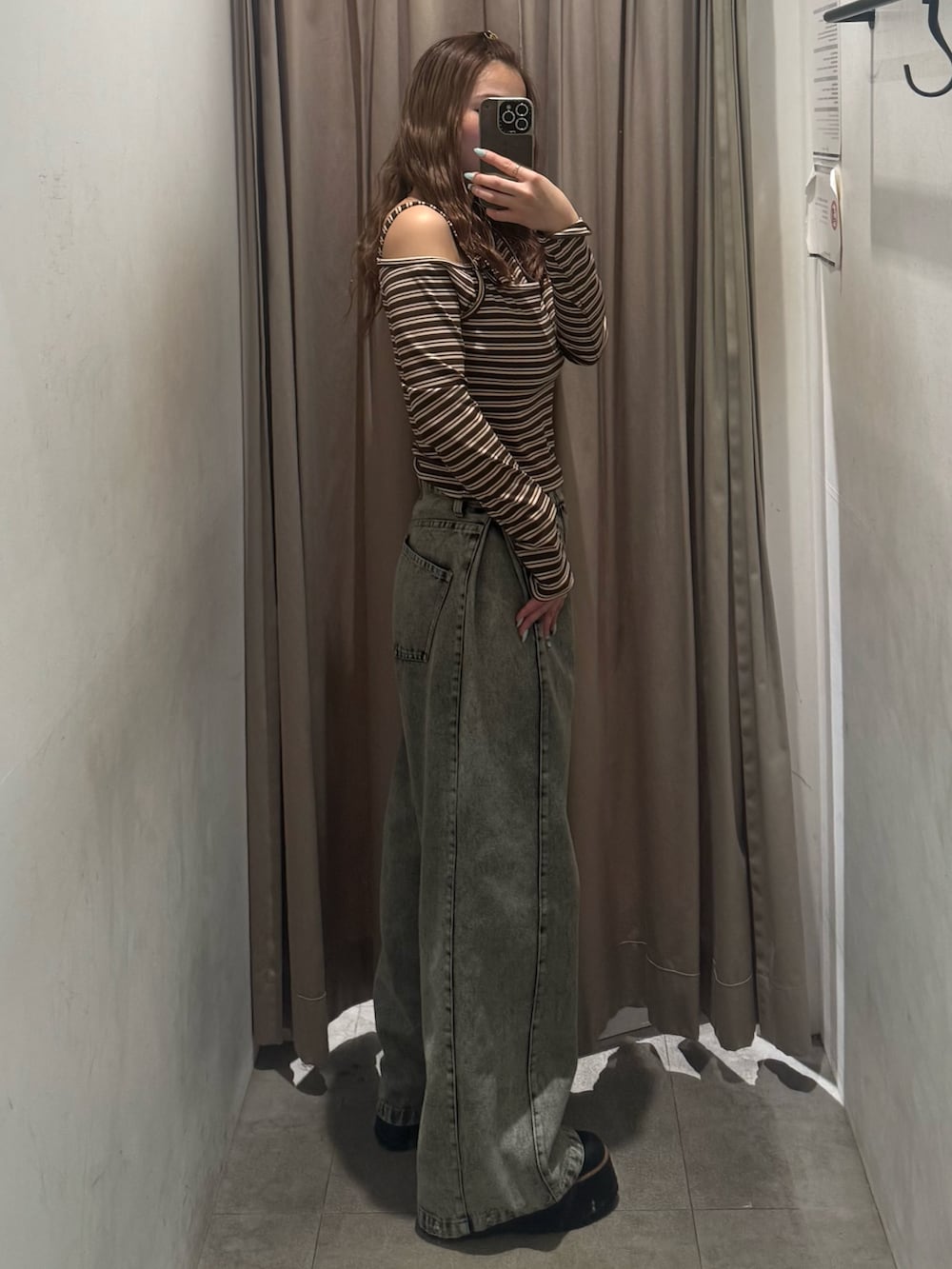 グリーン系のデニムパンツ、その他のニット/セーター、ブラック系のブーツを着用したレディースの冬コーディネートの2枚目の写真