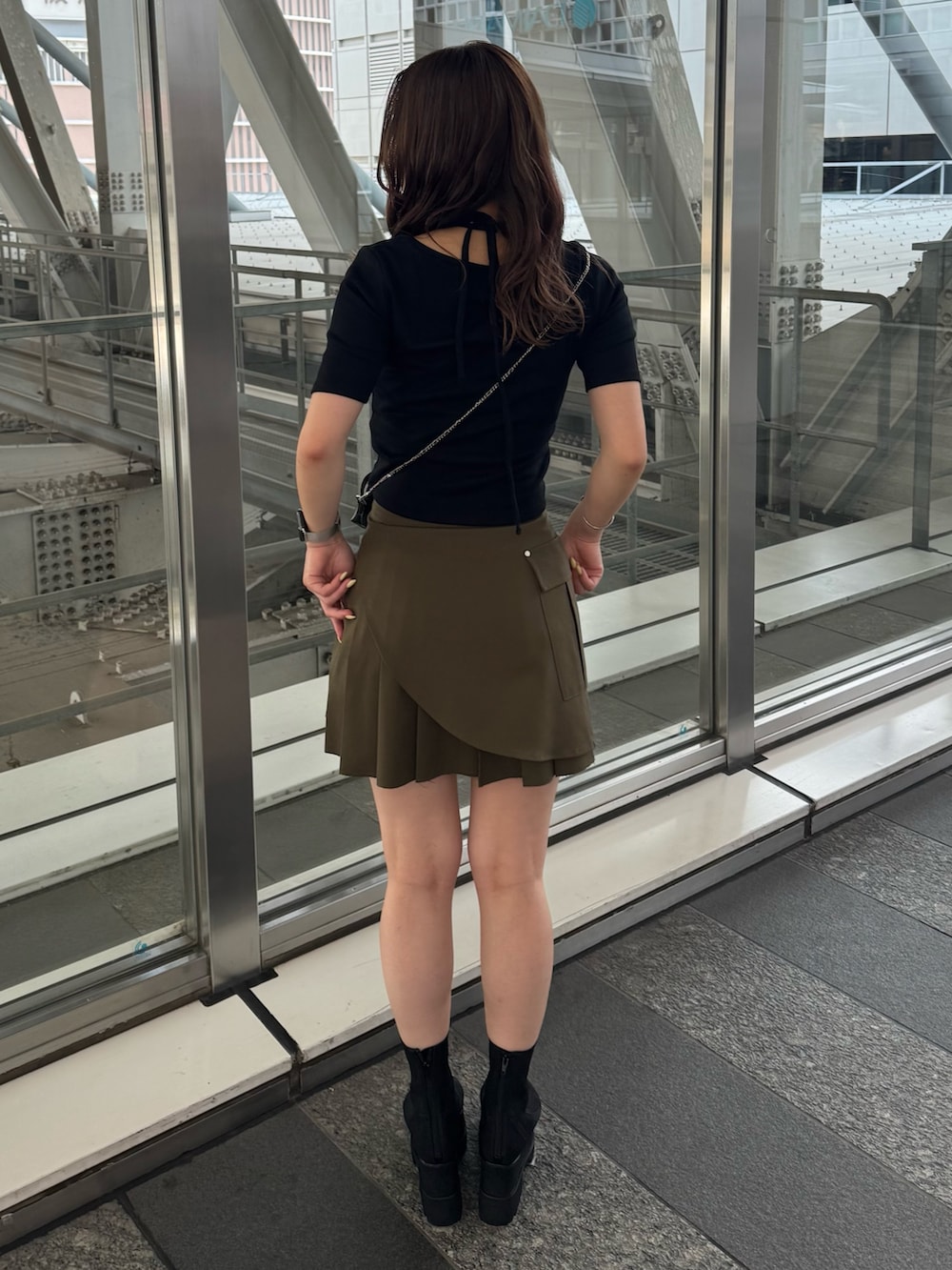 ブラック系のサンダル、グリーン系のスカート、ブラック系のTシャツ/カットソーを着用したレディースの夏コーディネートの3枚目の写真