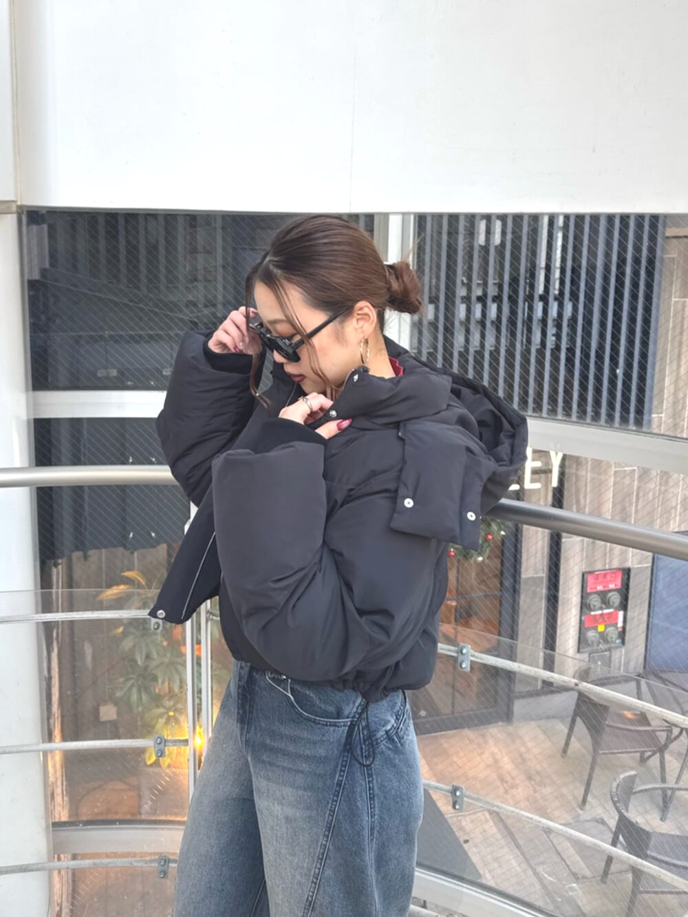 ブラック系のブーツ、ブルー系のデニムパンツ、レッド系のニット/セーターを着用したレディースの冬コーディネートの5枚目の写真