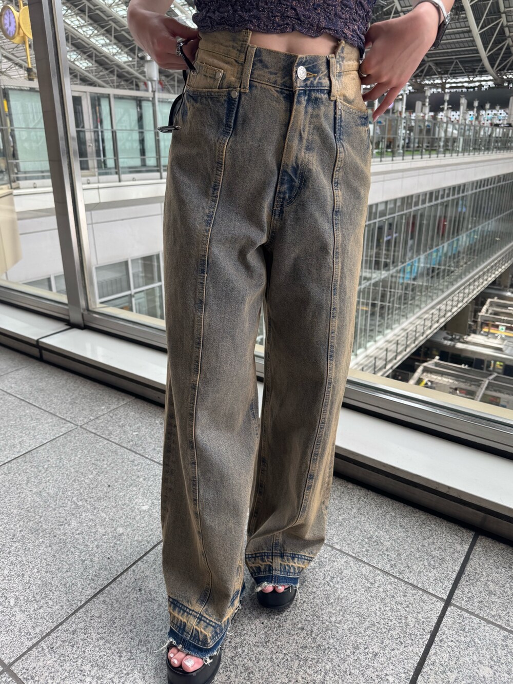 オレンジ系のタンクトップ、その他のデニムパンツ、ブラック系のサンダルを着用したレディースの春コーディネートの6枚目の写真
